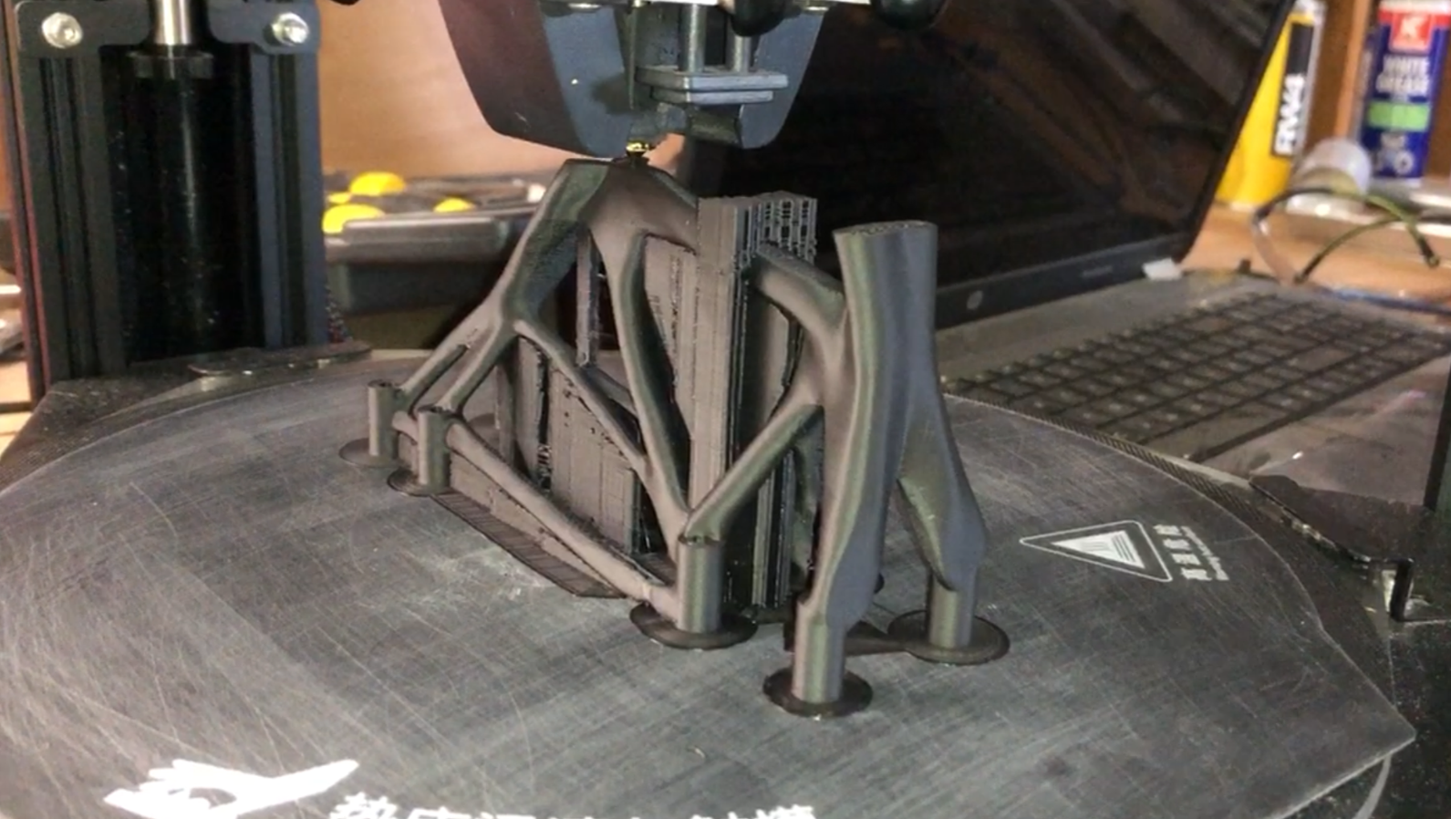 Delta 3D-printer die een generatief ontworpen motor mount uitprint.